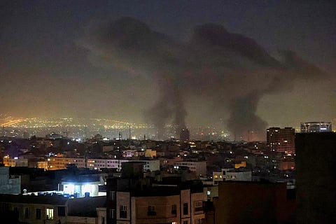 Plumes of smoke rise following reported explosions in Tehran early on March 3, 2026.