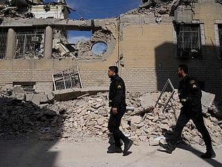 Policemen walk by a police facility struck during the US–Israeli military campaign in Tehran, Iran, Wednesday, March 4, 2026. 