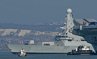 HMS Duncan, a Royal Navy Type 45 Daring-class air-defence destroyer warship, passes Royal Navy Aircraft Carrier HMS Prince of Wales (R) as it departs from HM Naval Base Portsmouth, on the south coast of England, on March 4, 2026.