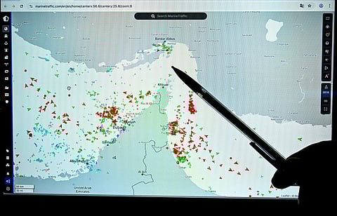 A person points at a page on the Marinetraffic website that shows commercial boats traffic on the edge of the Strait of Hormuz near the Iranian coast, in Paris on March 4, 2026.