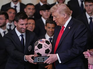 President Donald Trump passes over a soccer ball trophy from Lionel Messi during an event to honor the 2025 Major League Soccer champions