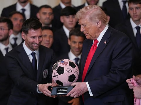 President Donald Trump passes over a soccer ball trophy from Lionel Messi during an event to honor the 2025 Major League Soccer champions