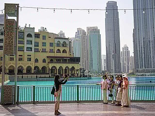 Tourists take photos near the Burj Khalifa in downtown Dubai, on Tuesday, March 3, 2026. 