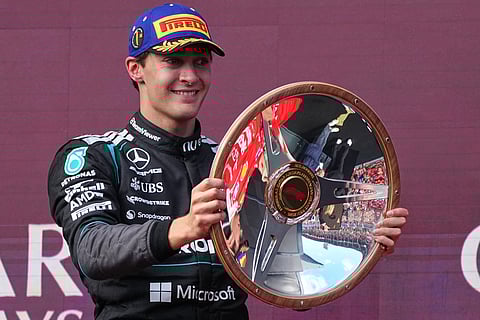 Mercedes driver George Russell of Britain celebrates on the podium with his trophy after winning the Australian Formula One Grand Prix 
