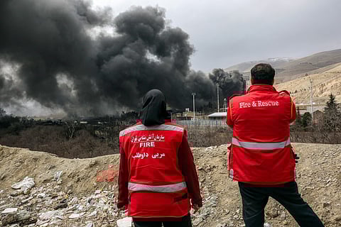 A thick plume of smoke rises from an oil storage facility hit by a U.S.-Israeli strike late Saturday in Tehran, Iran, Sunday, March 8, 2026.
