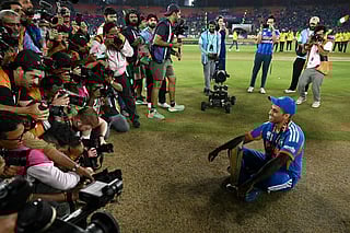 India's captain Suryakumar Yadav (R) pose with the trophy after his team's win in the 2026 ICC Men's T20 Cricket World Cup final match against New Zealand at the Narendra Modi Stadium in Ahmedabad on March 8, 2026.