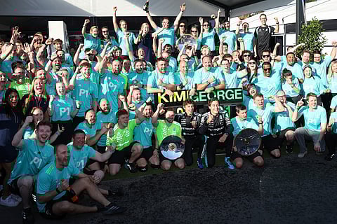 Mercedes’ British driver George Russell (5th R) and teammate Kimi Antonelli of Italy celebrate with team members after winning the Formula One Australian Grand Prix at Melbourne’s Albert Park Circuit on March 8, 2026.