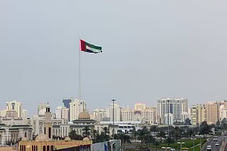 UAE flag with Sharjah skyline.