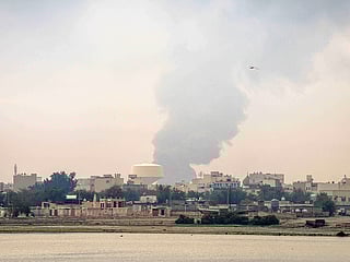 A plume of smoke rises after a reported Iranian strike on fuel tanks in Muharraq on March 12, 2026. Oil soared above $100 and stocks sank on March 12 as Iran's fresh attempts to hit supplies in the Middle East and threats to bring down the global economy overshadowed a record release of strategic crude by the International Energy Agency. Bahrain reported Iran had carried out an attack on fuel tanks in the country, while Saudi Arabia said it had intercepted drones headed to Shaybah oil field and drones struck fuel tanks at Oman's Salalah port, where operations were subsequently suspended. 