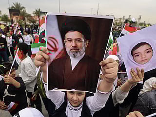 A schoolgirl holds up a poster of Iran's new supreme leader Mojtaba Khamenei during an anti-US and Israel demonstration in Baghdad on March 12, 2026. 
