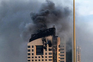 Smoke rises from a high-rise building following a drone attack in Kuwait City on March 8, 2026. 