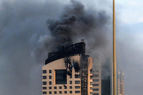 Smoke rises from a high-rise building following a drone attack in Kuwait City on March 8, 2026. 