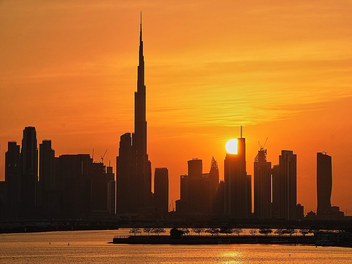 A view of the city skyline with Burj Khalifa is silhouetted during sunset in Dubai, on Thursday, March 12, 2026. 