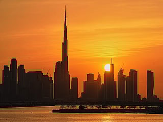 A view of the city skyline with Burj Khalifa is silhouetted during sunset at Dubai Creek Harbour in Dubai, Thursday, March 12, 2026. 