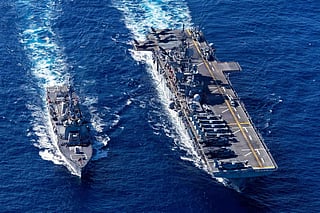 The US Navy destroyer USS Rafael Peralta refuels from the amphibious assault ship USS Tripoli during operations at sea. Amphibious ships like the Tripoli can deploy Marine Expeditionary Units during crises such as the current Iran war.