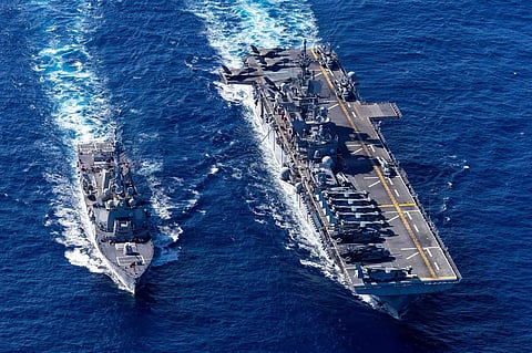 The US Navy destroyer USS Rafael Peralta refuels from the amphibious assault ship USS Tripoli during operations at sea. Amphibious ships like the Tripoli can deploy Marine Expeditionary Units during crises such as the current Iran war.