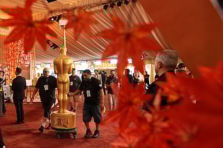 Workers install an Oscar statue Saturday, March 14, 2026, at the Dolby Theatre in Los Angeles, in preparation for Sunday's 98th Academy Awards ceremony. 