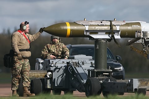 Military ground personnel are pictured next to cruise missiles which were unloaded from a US Air Force B-1 Lancer bomber on the tarmac at RAF Fairford in south-west England on March 11, 2026.