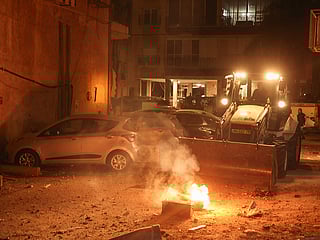 Israeli security works to put out a fire caused by a rocket strike in Holon, Israel.