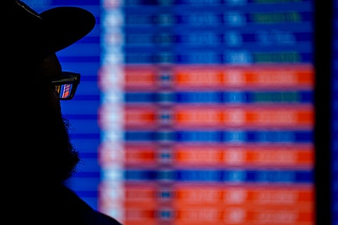 A man looks at a departure board displaying multiple canceled and delayed flights.