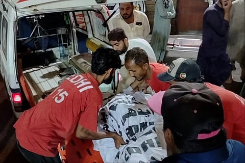 Rescue workers carry the body of a victim who died in an incident due to heavy rain strong winds, upon arrival at a hospital in Karachi, Pakistan, Thursday, March 19, 2026.  