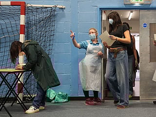 Students wait in line at the entrance to the sports hall at the University of Kent campus in Canterbury, England, where the rollout of a meningitis B vaccine to about 5,000 students has begun.