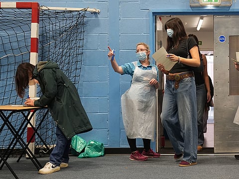 Students wait in line at the entrance to the sports hall at the University of Kent campus in Canterbury, England, where the rollout of a meningitis B vaccine to about 5,000 students has begun.