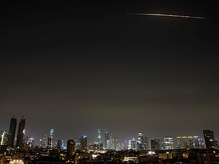The remains of an Iranian missile cross the sky over Tel Aviv after being intercepted early Saturday, March 21, 2026. 