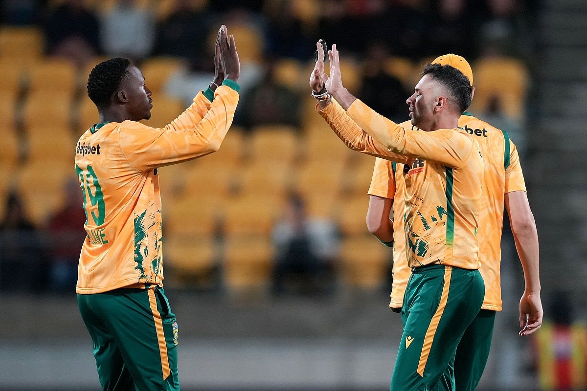South Africa captain Keshav Maharaj (R) celebrates bowling New Zealand's Cole McConchie with teammate Andile Simelane during the fourth Twenty20 international cricket match between New Zealand and South Africa in Wellington on March 22, 2026.