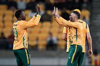 South Africa captain Keshav Maharaj (R) celebrates bowling New Zealand's Cole McConchie with teammate Andile Simelane during the fourth Twenty20 international cricket match between New Zealand and South Africa in Wellington on March 22, 2026.