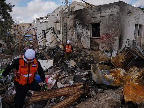 Israeli security forces survey the site that was struck by an Iranian missile in Dimona, southern Israel, Sunday, March 22, 2026. 