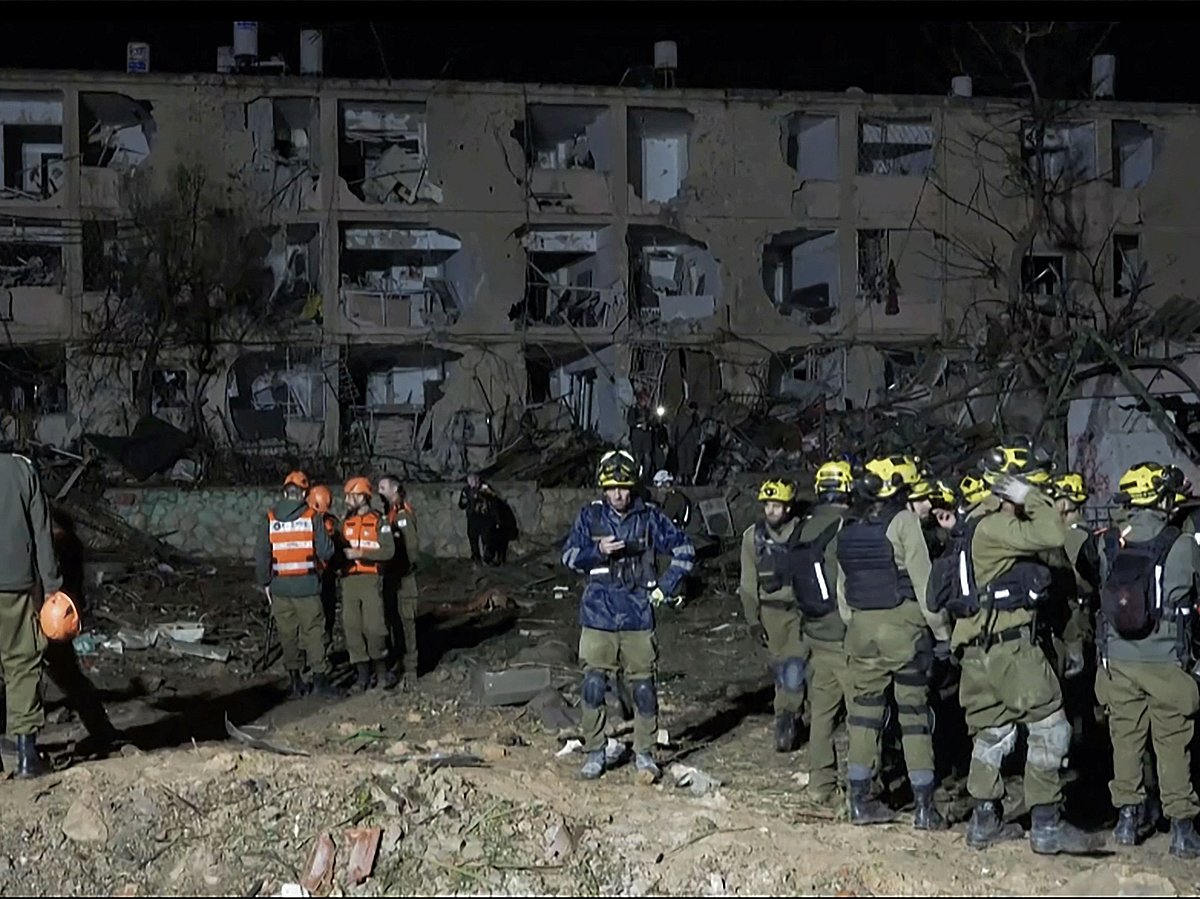 This frame grab from AFPTV footage shows first responders inspecting the site of an Iranian missile strike in Dimona on March 21, 2026. Two Iranian missiles struck southern Israel on March 21, injuring more than 100 people in the most destructive attack of the three-week war, with Prime Minister Benjamin Netanyahu vowing to retaliate "on all fronts". 