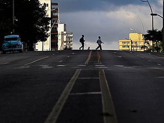 People cross a street during a nation wide blackout in Havana on March 22, 2026. 