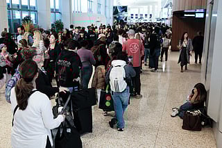 Passengers queue to go through security at New York's LaGuardia airport on March 22, 2026.