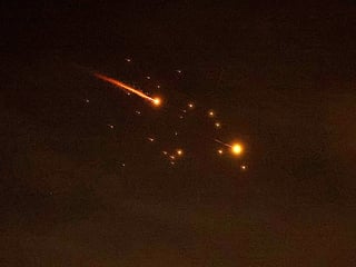 Rocket trails are seen in the sky amid a fresh barrage of Iranian missile attacks above the Israeli coastal city of Netanya on March 23, 2026. 