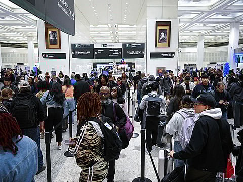 Travellers wait in line at a TSA security checkpoint at George Bush Intercontinental Airport in Houston, Texas on March 20, 2026. 