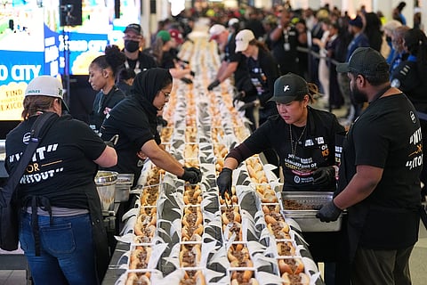 Volunteers assemble cheesesteaks in a Guinness World Record attempt on National Cheesesteak Day at Philadelphia International Airport, Tuesday, March 24, 2026, in Philadelphia.
