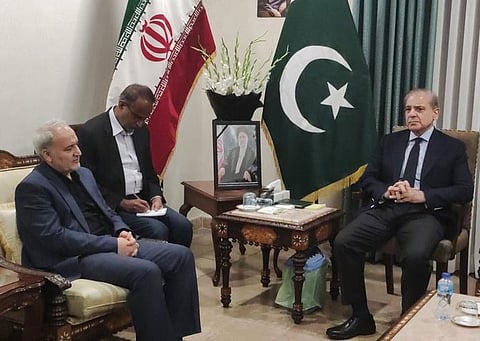 Pakistan’s Prime Minister Shehbaz Sharif and Iran’s ambassador to Pakistan Reza Amiri Moghadam — as Islamabad emerges as a key backchannel, even as Tehran insists no talks with the US are underway.