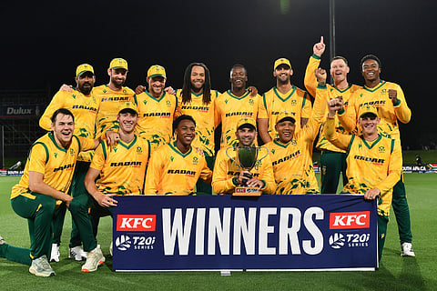 South Africa's Keshav Maharaj (front 3rd R) holds the series trophy as he and his teammates pose after winning the fifth Twenty20 international cricket match between New Zealand and South Africa at Hagley Oval in Christchurch on March 25, 2026.