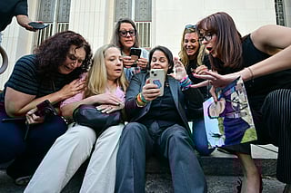 Laura Marquez-Garrett (Centre, grey blazer), plaintiffs' attorney for SMVLC (Social Media Victims Law Centre), gathers with parents and family members of victims as they react to news that the jury has found Meta and YouTube liable in the social media addiction trial, outside the Los Angeles Superior Court , in Los Angeles, on March 25, 2026.