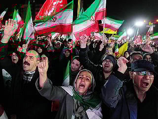 Pro-government supporters chant slogans and wave Iranian flags during a rally, in a square in western Tehran, Iran, Wednesday, March 25, 2026.