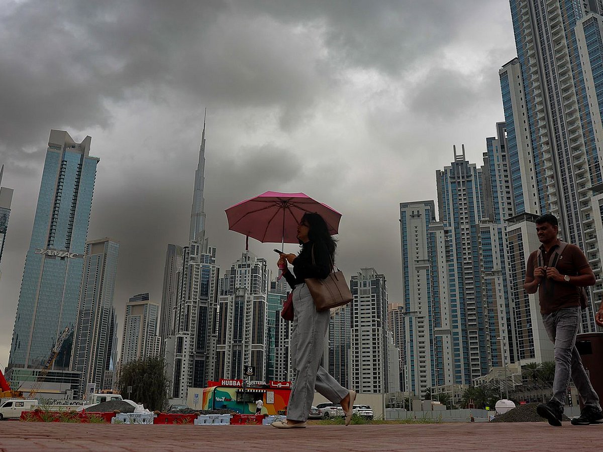 Dark clouds loom over Dubai’s iconic skyline, with the Burj Khalifa rising in the background.