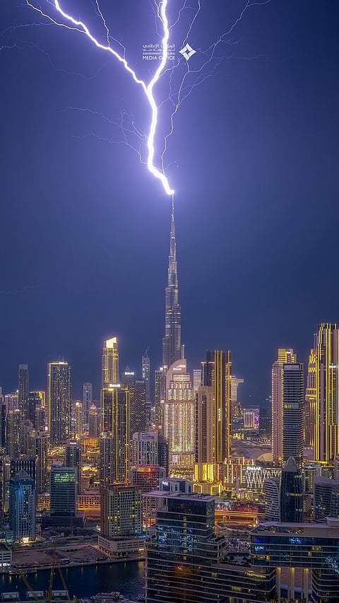 A blinding bolt tears through the storm and strikes the lightning rod atop the Burj Khalifa, as thunder rolls across Dubai and relentless rain lashes the UAE skyline