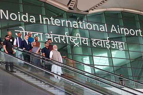 This handout photograph taken on March 28, 2026 and released by the Indian Press Information Bureau (PIB) shows Prime Minister Narendra Modi (C) riding an escalator after the inauguration of the Noida International Airport in Jewar, Uttar Pradesh state.