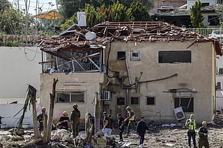 First responders assess the damage after a house was hit by a projectile strike in Eshtaol, near Beit Shemesh in central Israel, on March 28, 2026.