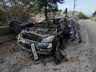A policeman checks the charred car that was carrying Hezbollah's al-Manar TV correspondent Ali Shoeib, Beirut's based Al-Mayadeen TV reporter Fatima Ftouni and her brother, video journalist Mohammed Ftouni, before they were killed in an Israeli airstrike, in the town of Jezzine, south Lebanon, Saturday, March 28, 2026. 