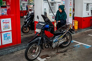 A motorcyclist refuels her bike at a gas station operated by Pertamina, Indonesia’s state-owned oil and gas company, as the closure of the Strait of Hormuz by Iran disrupts energy flows and global oil prices rise, prompting Indonesia to consider a weekly work-from-home policy to cut fuel use, in Yogyakarta. File photo taken on March 28, 2026.