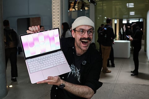 A man holds the newly released MacBook Neo during the "Special Apple Experience" launch event at the Apple Store in the Manhattan borough of New York City, on March 4, 2026.