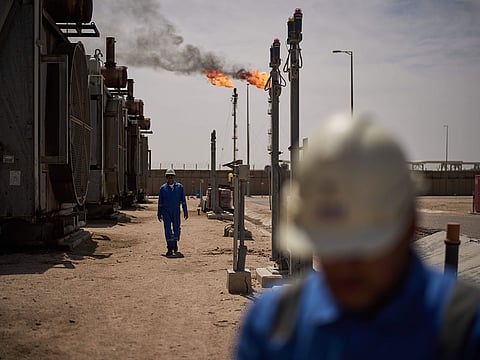Workers walk in an area at a degassing station in Zubair oil field, whose operations have been reduced due to the Mideast war triggered by the US and Israeli attacks on Iran, near Basra, Iraq, Saturday, March 28, 2026. 