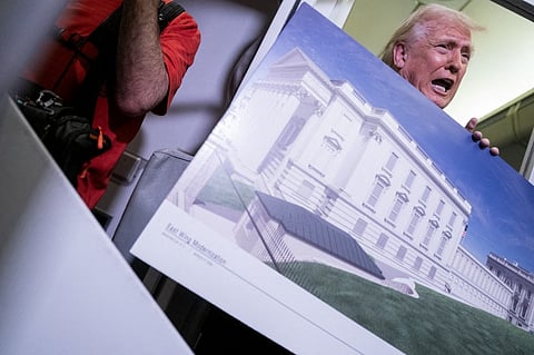President Donald Trump holds a rendering of the proposed East Wing of the White House while speaking to members of the media onboard Air Force One on March 29, 2026 while en route to Joint Base Andrews, Maryland from West Palm Beach Florida.